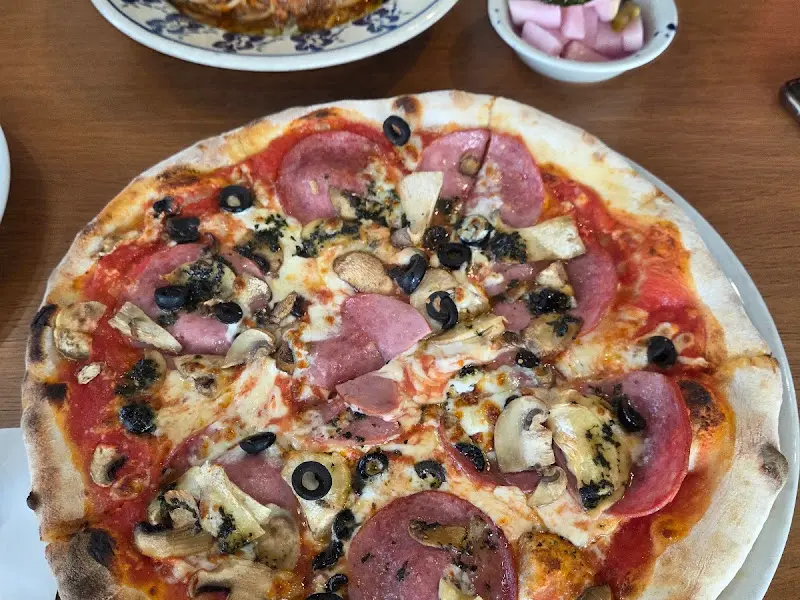 페퍼로니, 버섯, 올리브가 토핑된 피자의 모습