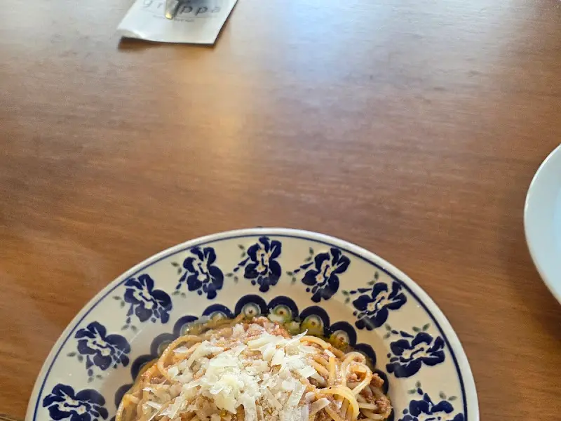 크림 파스타 위에 치즈 가루가 뿌려진 모습