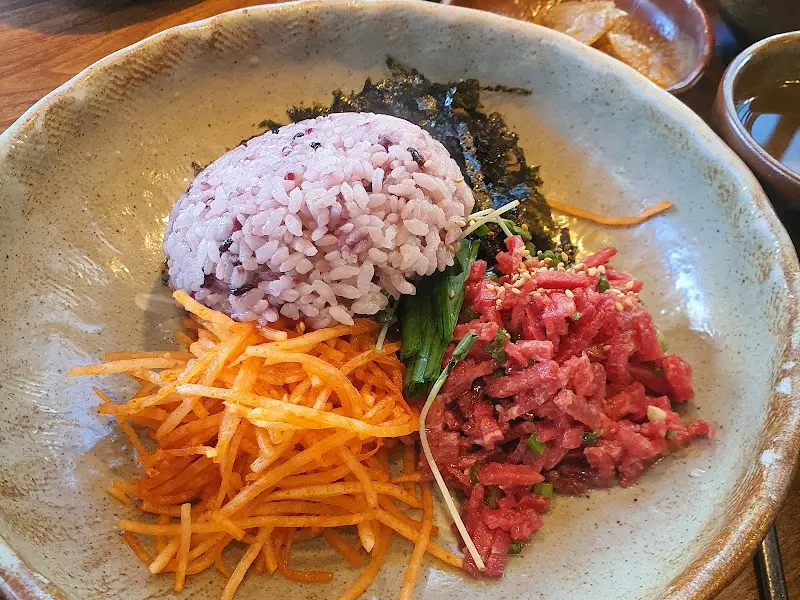 밥 위에 올려진 윤기 흐르는 육회와 고추장의 조화