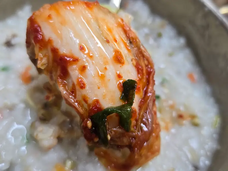 바지락죽 위에 김치 한 점