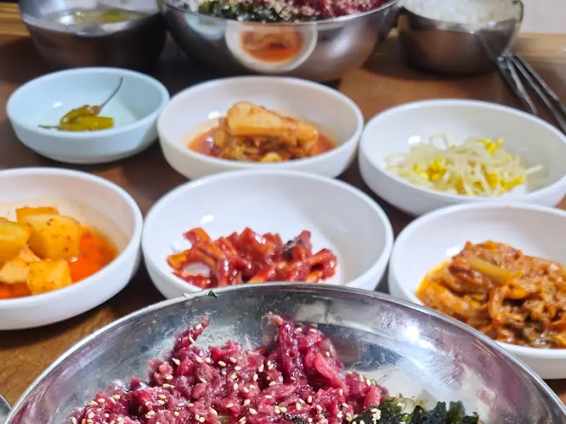 한 상 가득 차려진 생고기 비빔밥과 밑반찬