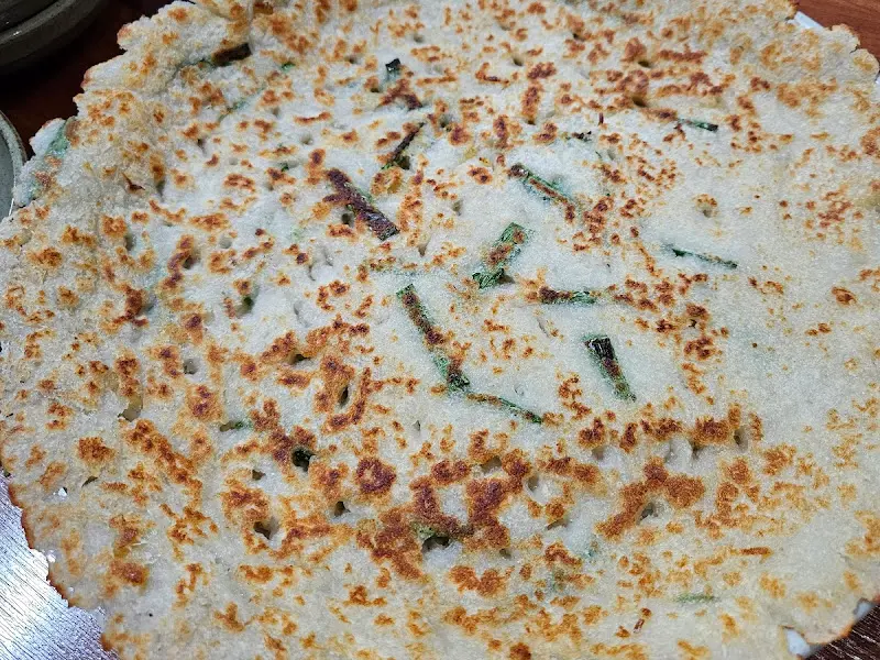 감자전의 클로즈업 사진. 감자전 위에 파가 뿌려져 있다.