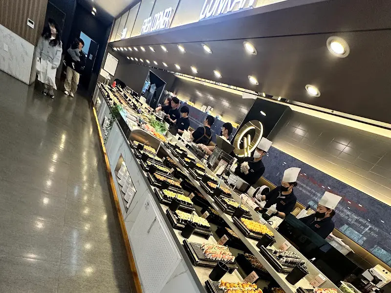 길게 늘어선 초밥 코너, 다양한 종류의 초밥과 롤이 시선을 사로잡는다.