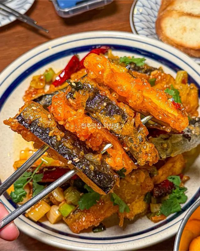 젓가락으로 집어 올린 어향가지 튀김