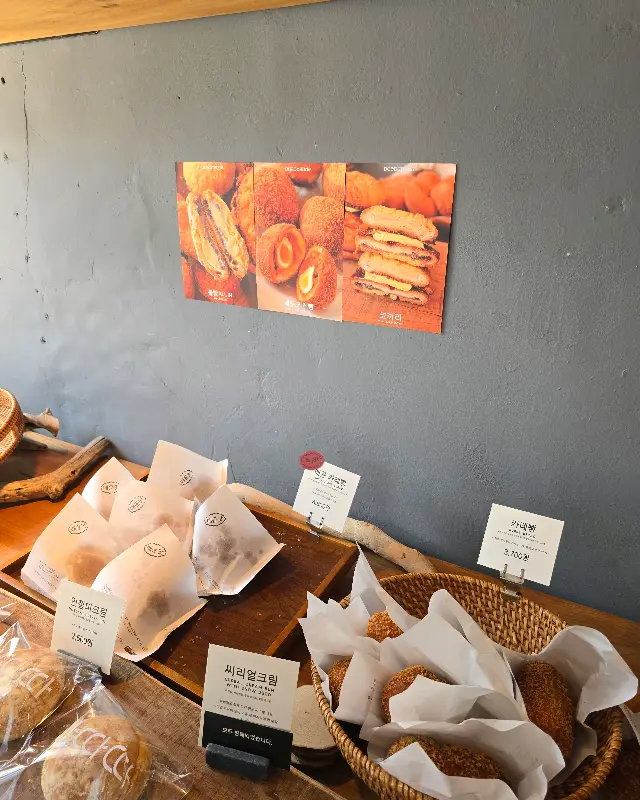 벽에 붙은 메뉴 사진과 빵 진열대