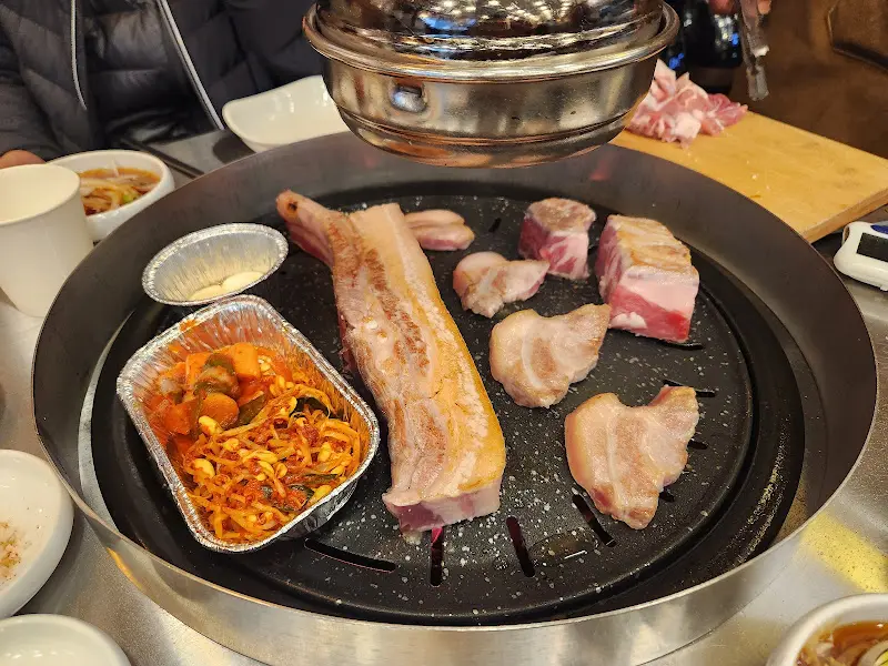 불판 위에 올려진 주먹고기와 멜젓