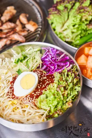 다채로운 밑반찬과 쫄면이 함께 차려진 모습