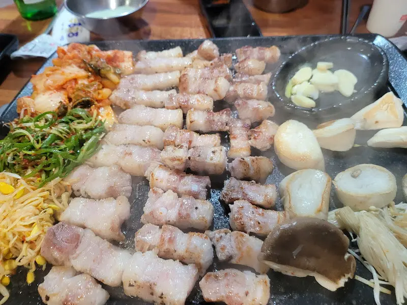 불판 가득 올려진 삼겹살과 гарнир
