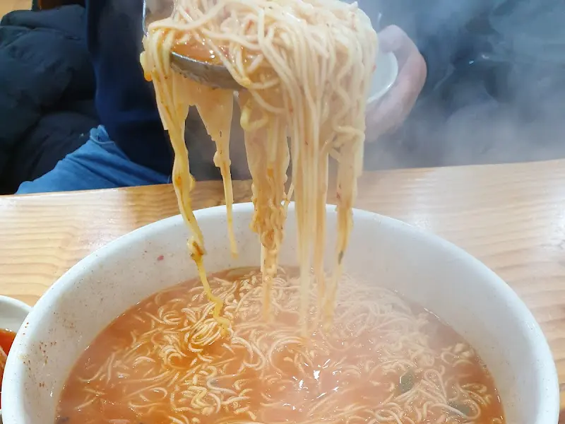 생선국수를 푸짐하게 담아 올리는 모습