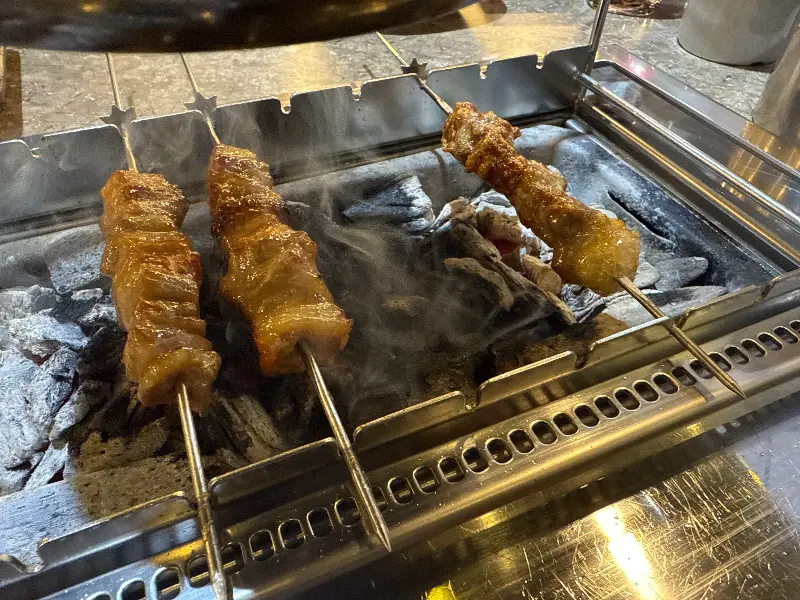 숯불 위에서 연기를 내며 익어가는 양꼬치