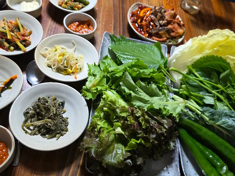 다양한 쌈 채소와 밑반찬이 푸짐하게 차려진 모습