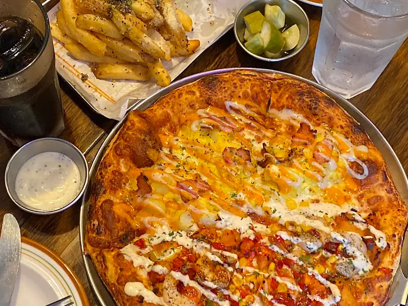 반반 피자, 감자튀김, 음료가 놓인 테이블