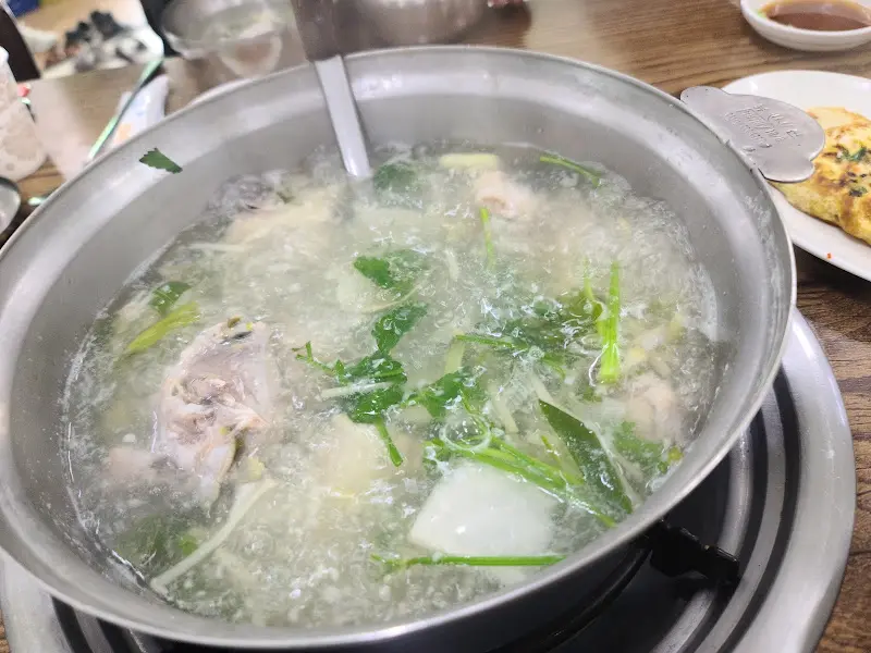 뽀얀 국물 위로 미나리와 콩나물이 수북하게 쌓인 복지리