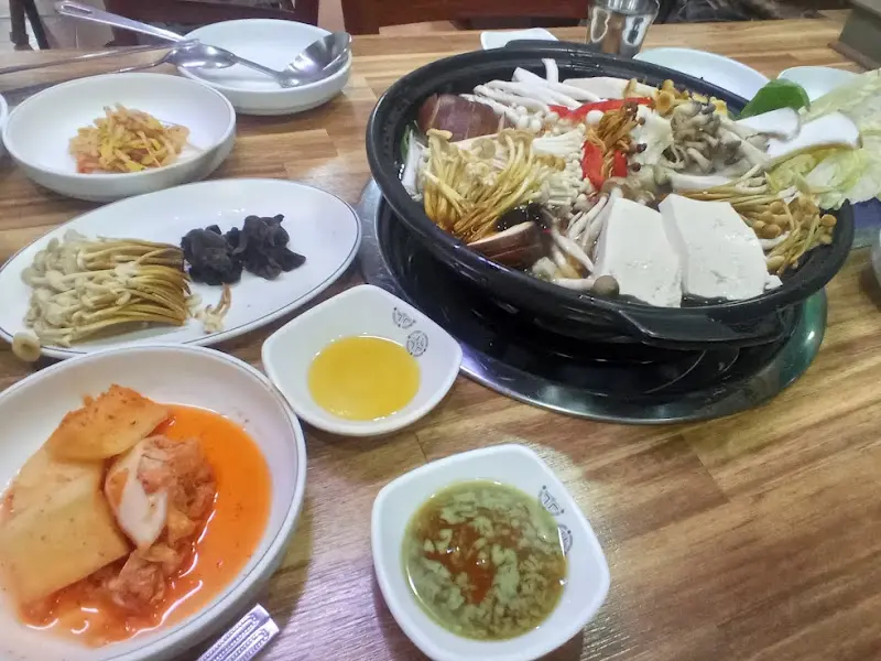 소고기버섯전골과 다양한 밑반찬이 차려진 테이블 전경