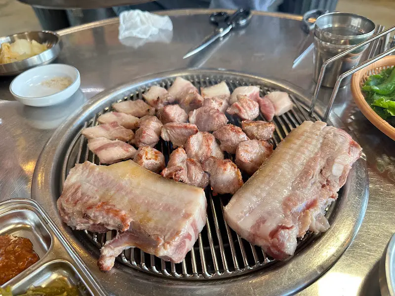 잘 구워진 흑돼지를 불판 위에 가지런히 놓아둔 모습