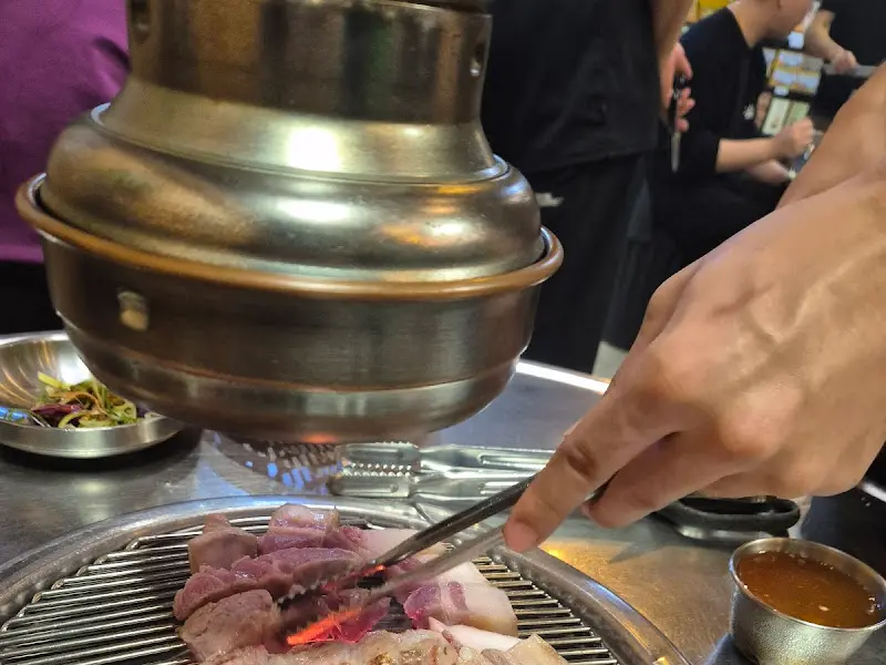 테이블에서 연탄불로 흑돼지를 굽는 모습