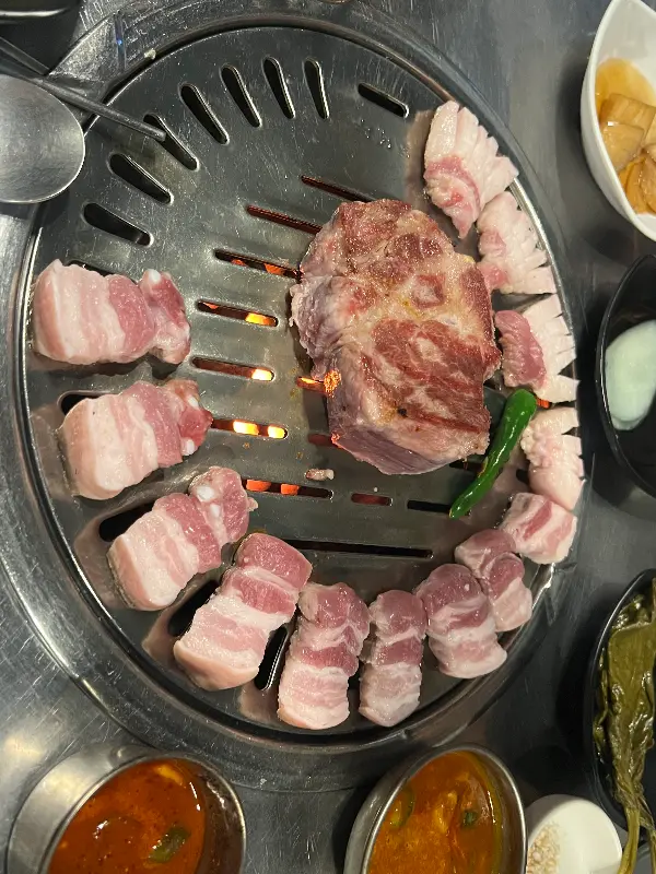 연탄불 위에서 익어가는 흑돼지 근고기의 모습