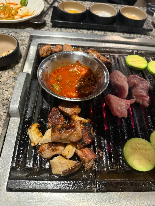 불판 위에 구워지고 있는 고기와 버섯, 꽈리고추