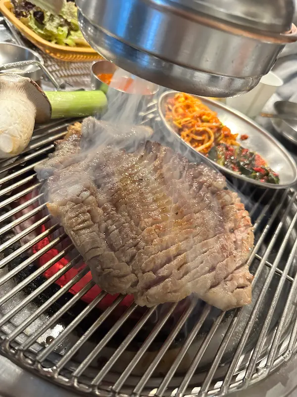 두툼한 돼지 생갈비가 숯불 위에서 익어가는 모습