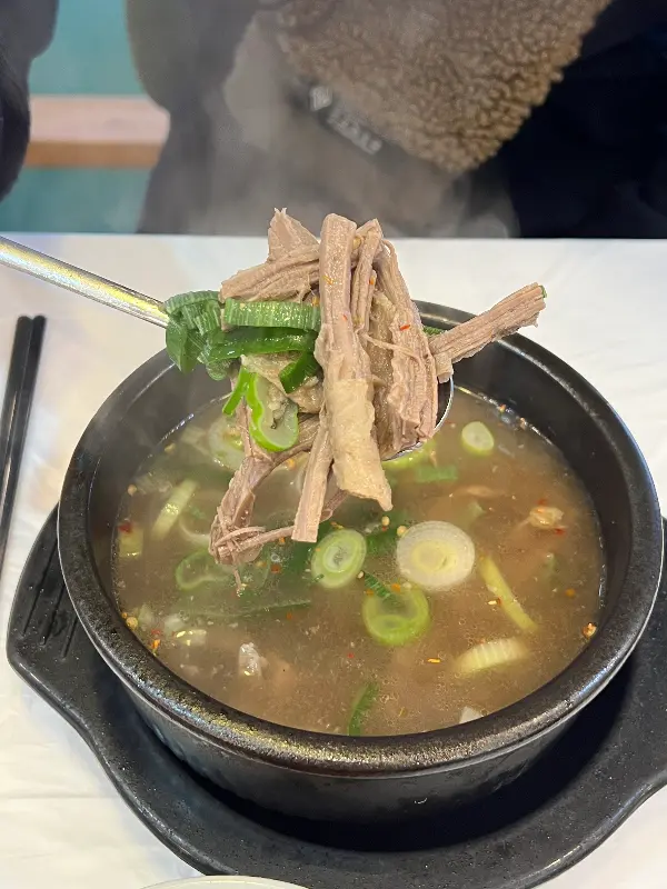 국밥 안의 고기를 숟가락으로 들어올린 모습