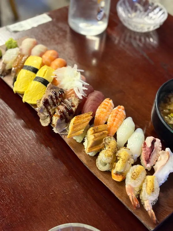 나무 도마 위에 가지런히 놓인 오마카세 초밥