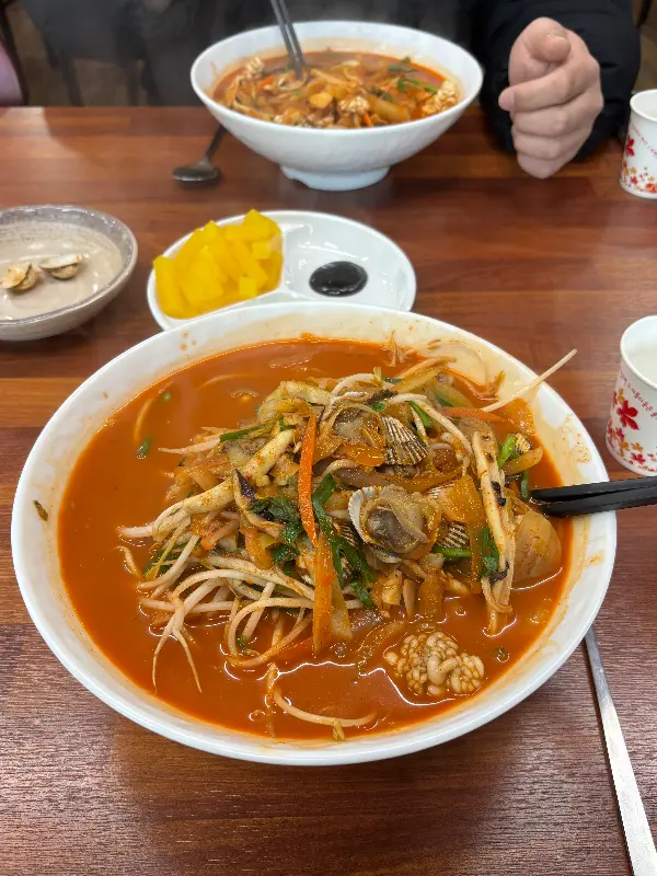 테이블 가득 차려진 꼬막짬뽕과 짜장면