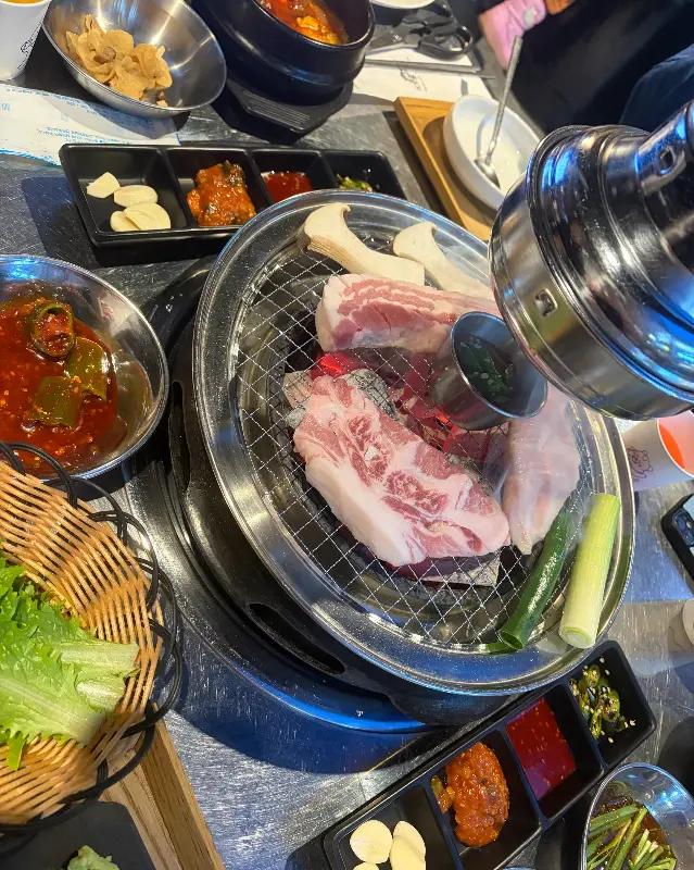 맛있게 익어가는 고기와 푸짐한 밑반찬