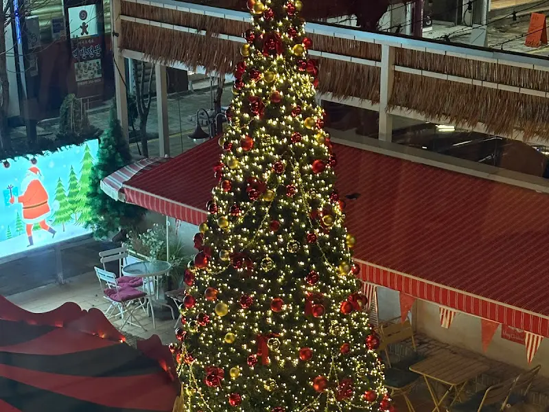 2층에서 내려다본 카페 앞마당의 크리스마스 트리 사진. 붉은색과 금색 장식들이 화려하다.