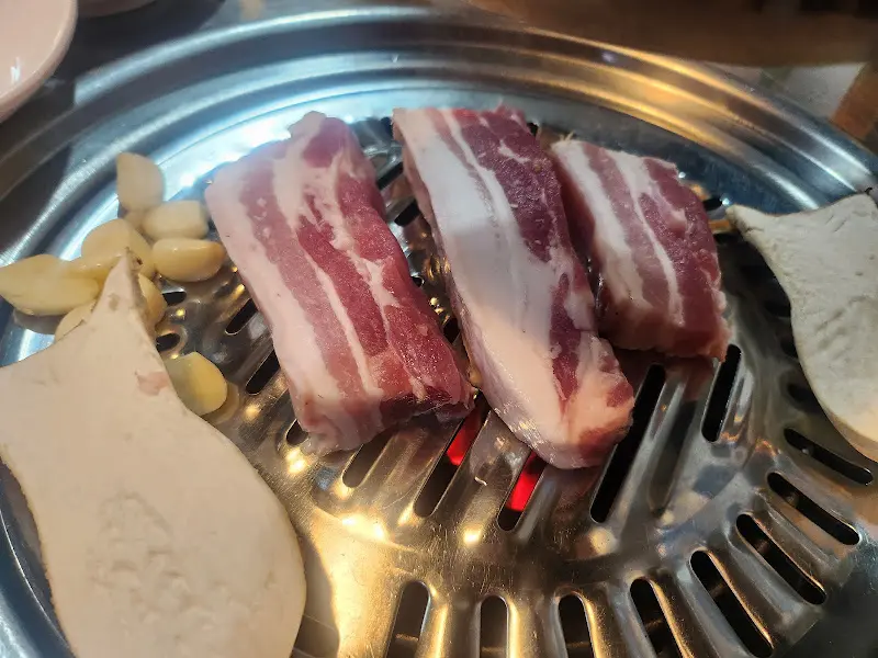 불판 위에서 익어가는 흑돼지 삼겹살