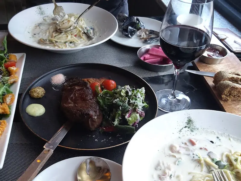 스테이크와 파스타, 와인잔이 놓인 테이블