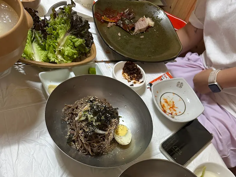 회 막국수에 동치미 육수를 붓는 모습