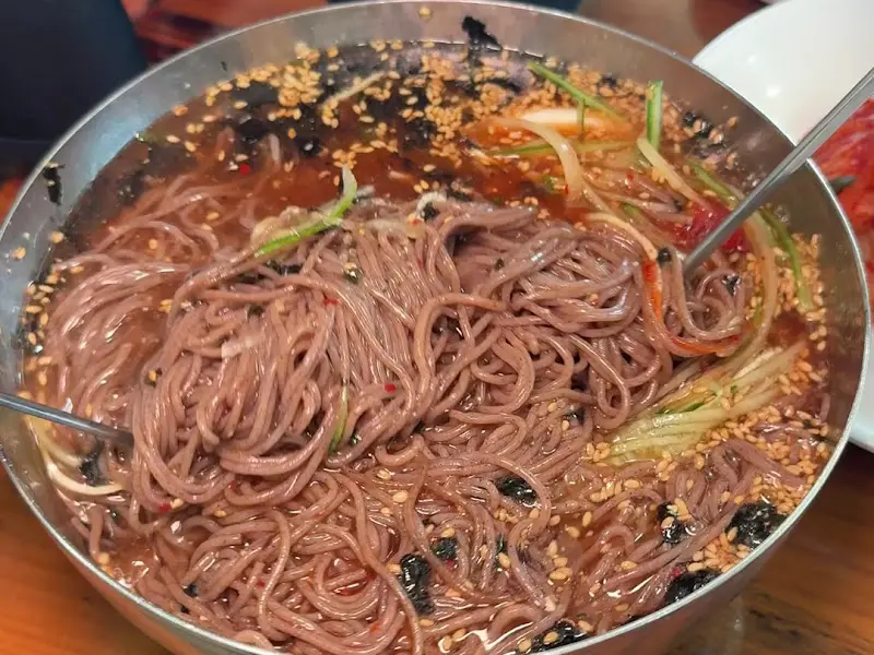 젓가락으로 막국수를 비비는 모습