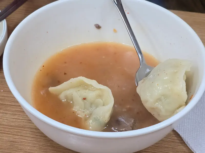만두국에 숟가락이 담긴 모습