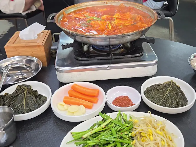 두루치기 찌개와 깻잎, 마늘, 고추장 등 밑반찬이 차려진 모습