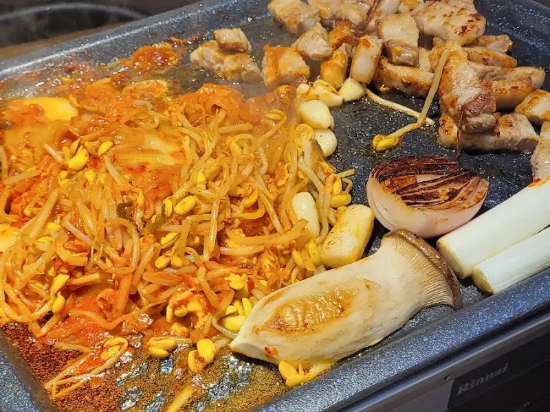 노릇하게 구워진 삼겹살과 김치, 콩나물