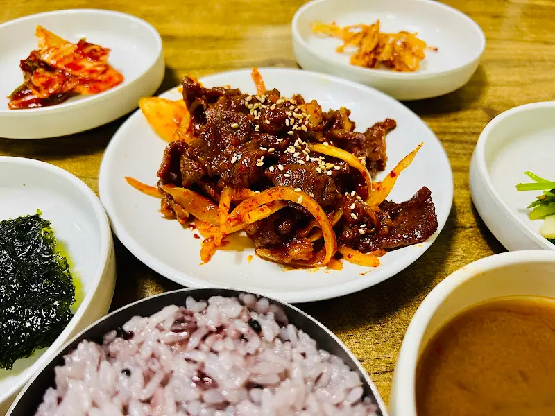 윤기가 흐르는 흑미밥과 제육볶음, 다양한 밑반찬