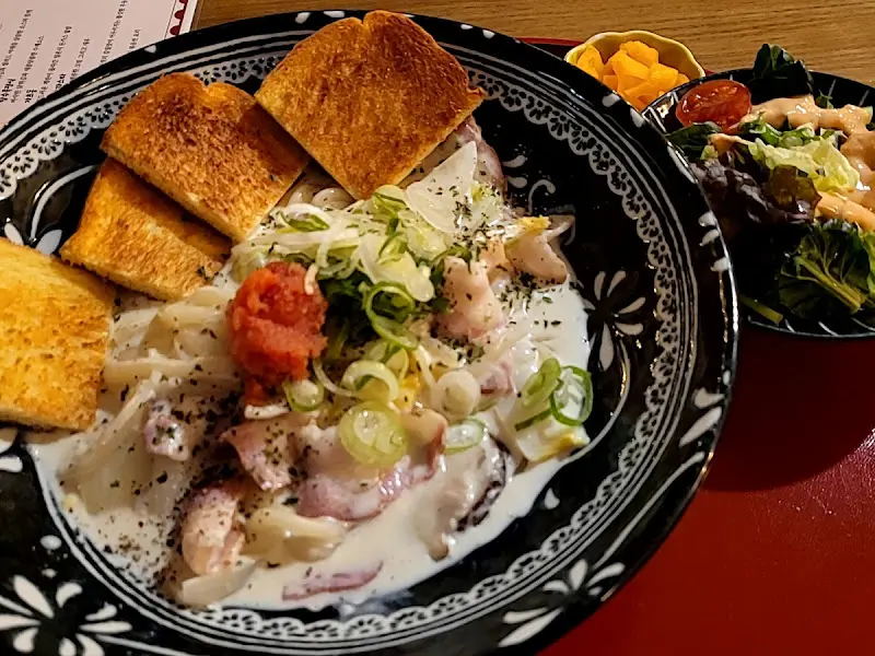 크림 소스 파스타 위에 구운 식빵이 곁들여진 메뉴 사진