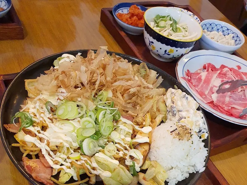 가쓰오부시가 듬뿍 올라간 음식과 곁들임 반찬, 소스가 함께 담겨 나온 한 상차림