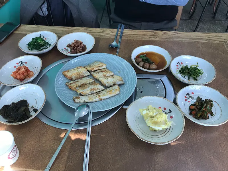 다양한 반찬과 구워진 오리고기