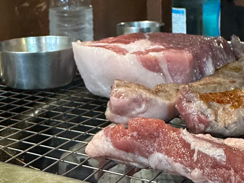 숯불 위에서 구워지는 두툼한 돼지고기