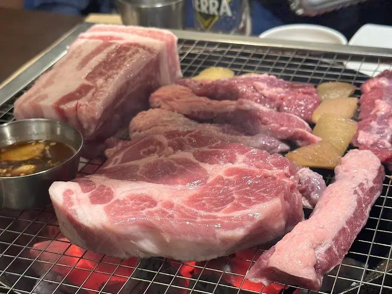 숯불 위에서 익어가는 다양한 부위의 돼지고기