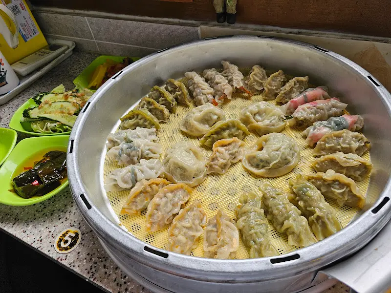 다양한 만두와 곁들임 반찬이 놓인 테이블