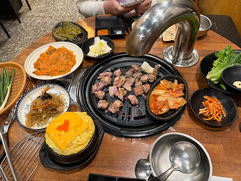 다양한 쌈채소와 반찬, 고기가 가득한 테이블