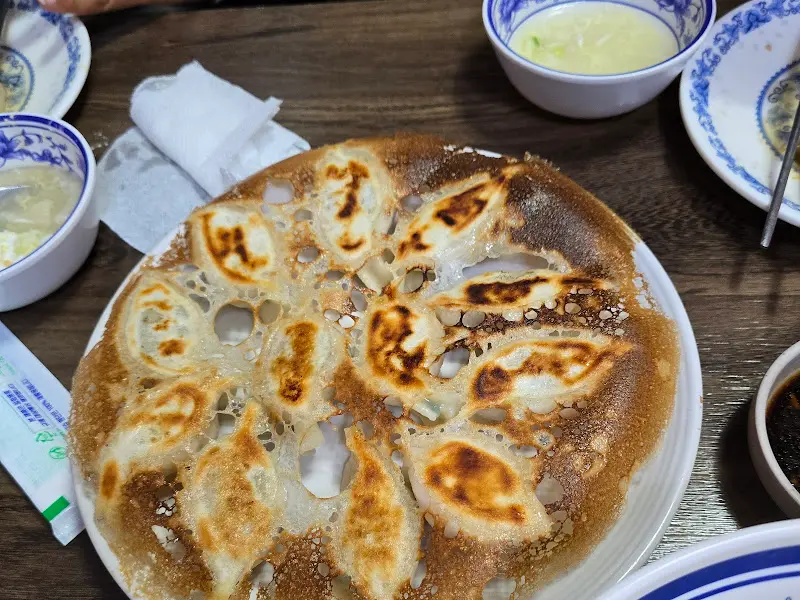 빙화만두가 담긴 접시와 간장 종지, 그리고 수저가 놓여 있다.