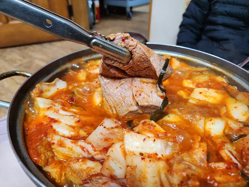 집게로 들어올린 돼지고기