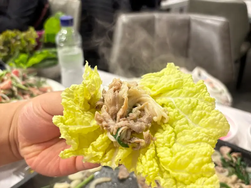 오리고기를 쌈에 싸서 먹는 모습