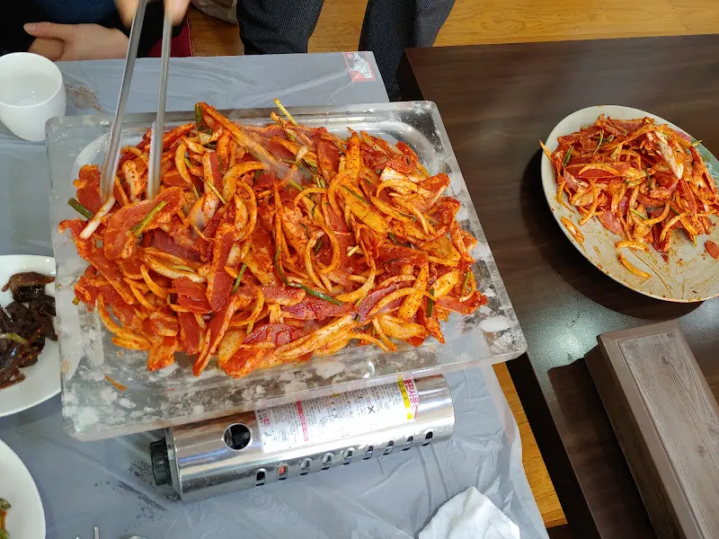 불판 가득 올려진 더덕오리구이와 밑반찬