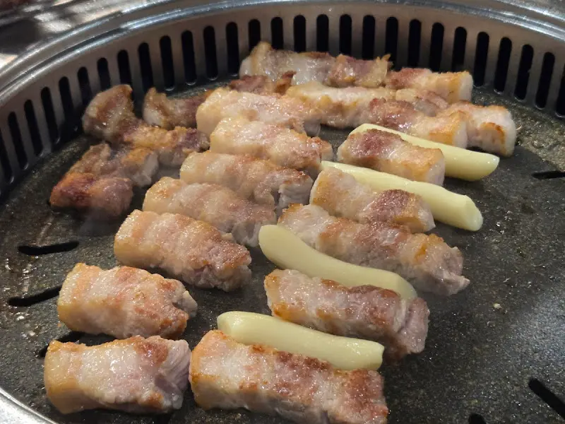 맛찬들 왕소금구이 정자점의 구운 치즈와 떡을 곁들인 삼겹살