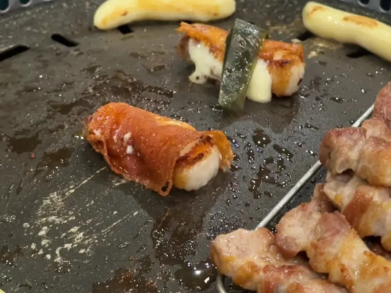 맛찬들 왕소금구이 정자점의 삼겹살, 치즈, 떡, 명이나물 조합