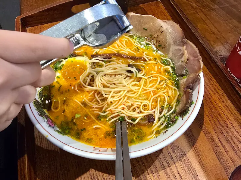 마늘을 으깨 라멘에 넣는 모습